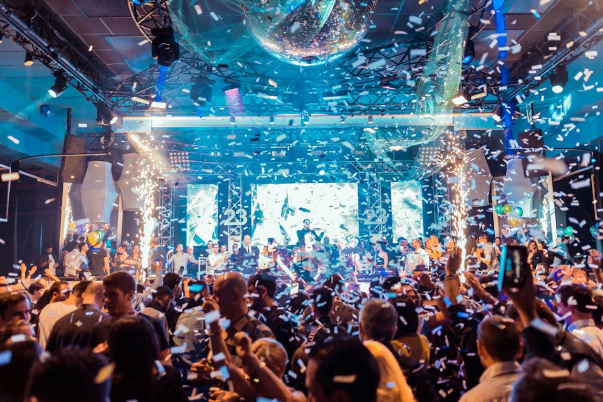 Crowd at a company event with stage lights and confetti
